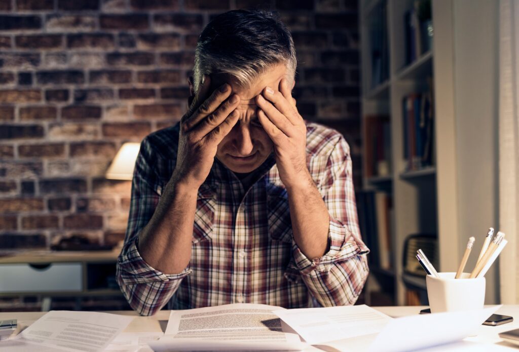 A stressed man experiencing tax debt and hoping to obtain an IRS offer in compromise
